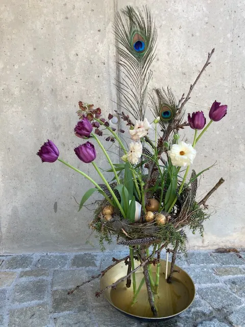 Kunstvolles Tulpen-Arrangement mit Pfauenfeder in Messingschale